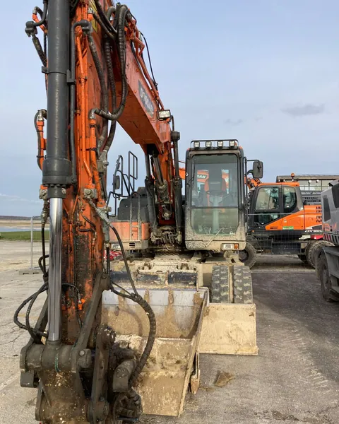 Close view of an excavator's boom, cab and bucket