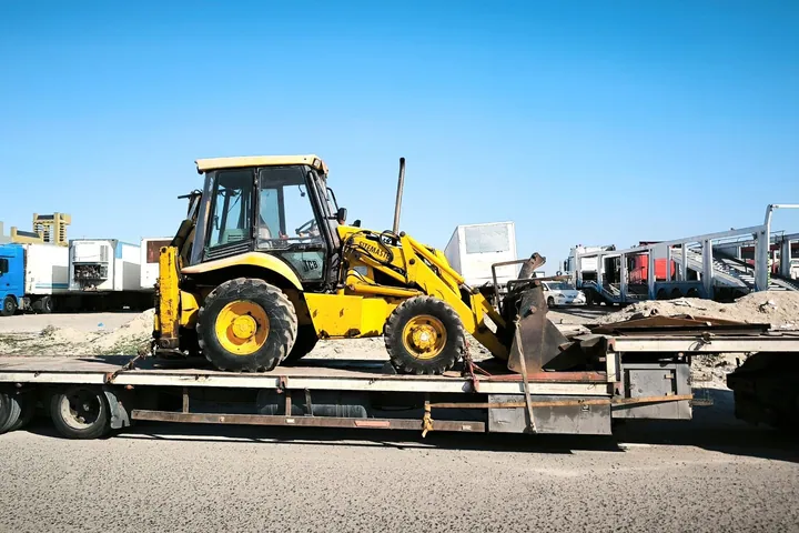 Construction machine secured on a flatbed trailer