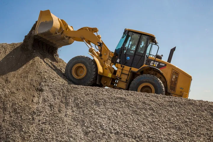 Front loader moving a mound of gravel