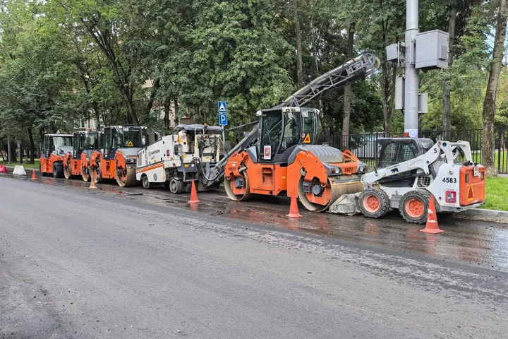 Road construction machinery lined up beside a street